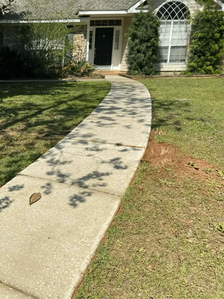 <alt=“After concrete sidewalk pressure washing in Mobile County, Alabama showing clean bright walkway with fully restored surface.”>