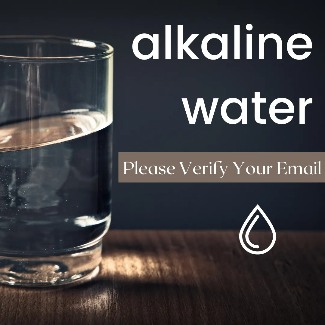 A simple yet elegant image of a glass filled with alkaline water on a wooden surface, overlaid with the white text 'alkaline water' and the instruction 'Please Verify Your Email' below. A single water droplet icon emphasizes the theme of purity and hydration, while the request adds an interactive call to action for the viewer.