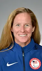 Elizabeher with long reddish hair wearing a  blue USA paralympic jacket