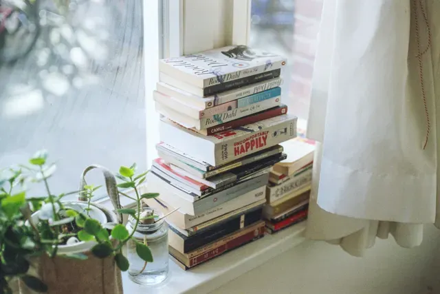 a stack of books. Use books that fit your goals in order to plan your budget and grow your business.