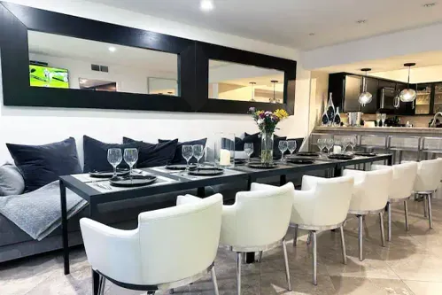 Welcome to Entertaining Modern Living! Gather in this spacious Dining & Bar Lounge with a long table for larger groups. Enjoy the 70-inch 4K Smart TV and step outside to the outdoor SPA patio. Perfect for memorable moments with family & friends!