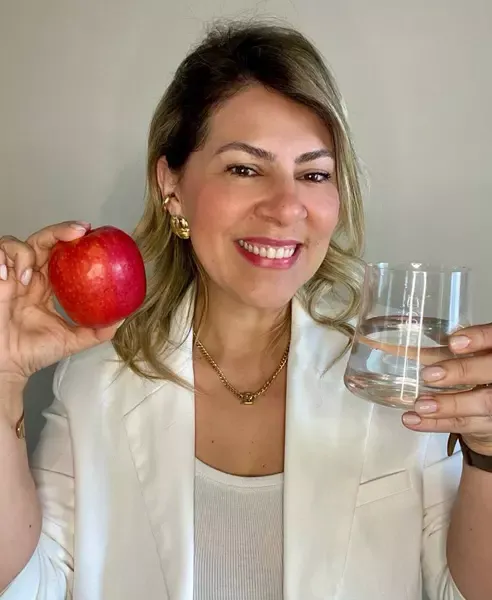 Doutora Érica Moura Segundando uma Maça e Copo com água 2
