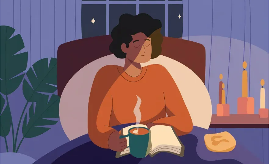 A person practicing a calming nighttime routine, including reading a book with a warm mug of herbal tea next to them in a softly lit room. 