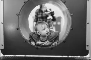 Image of child looking through port hole