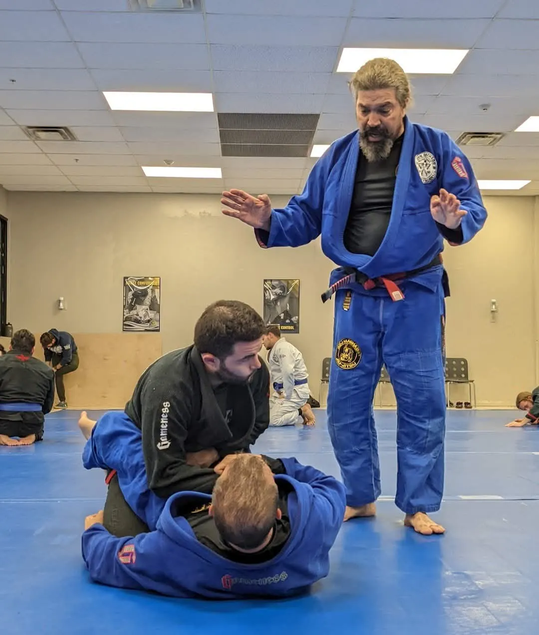 Professor John D. Machado teaching Brazilian Jiu-Jitsu techniques to students during a training session.