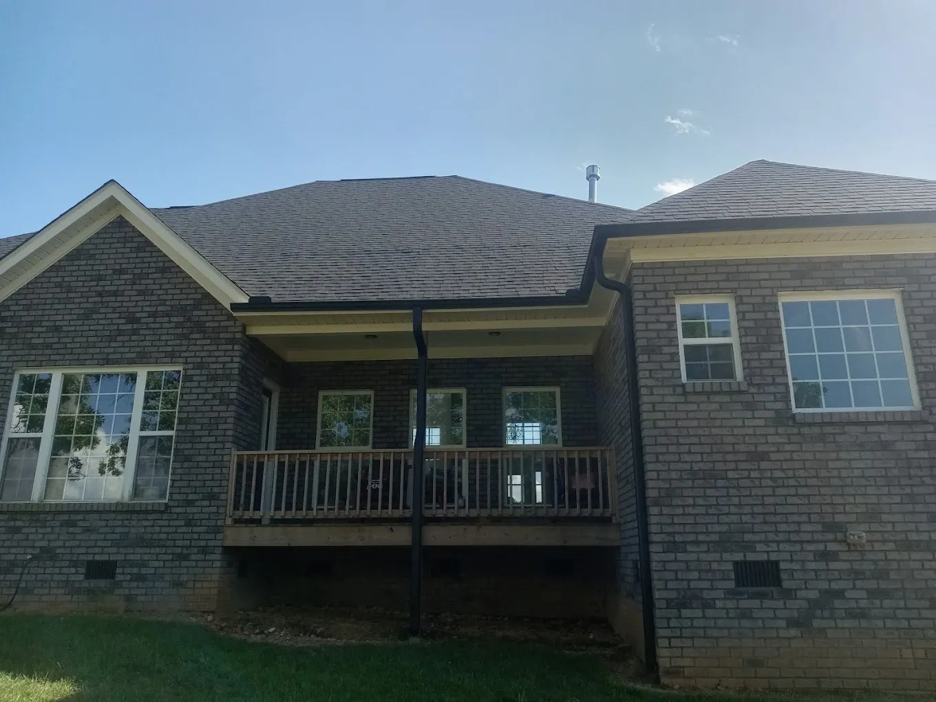 residential brick home with black seamless gutters 