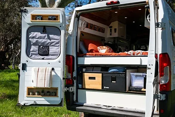 Campervan rear setup with outdoor shower clothesline and fishing storage