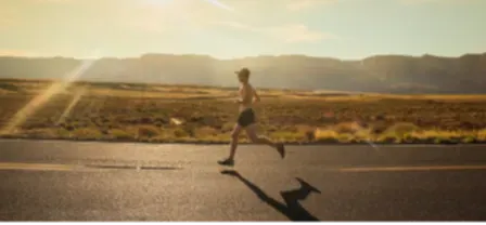 man running on a road in desert on a road