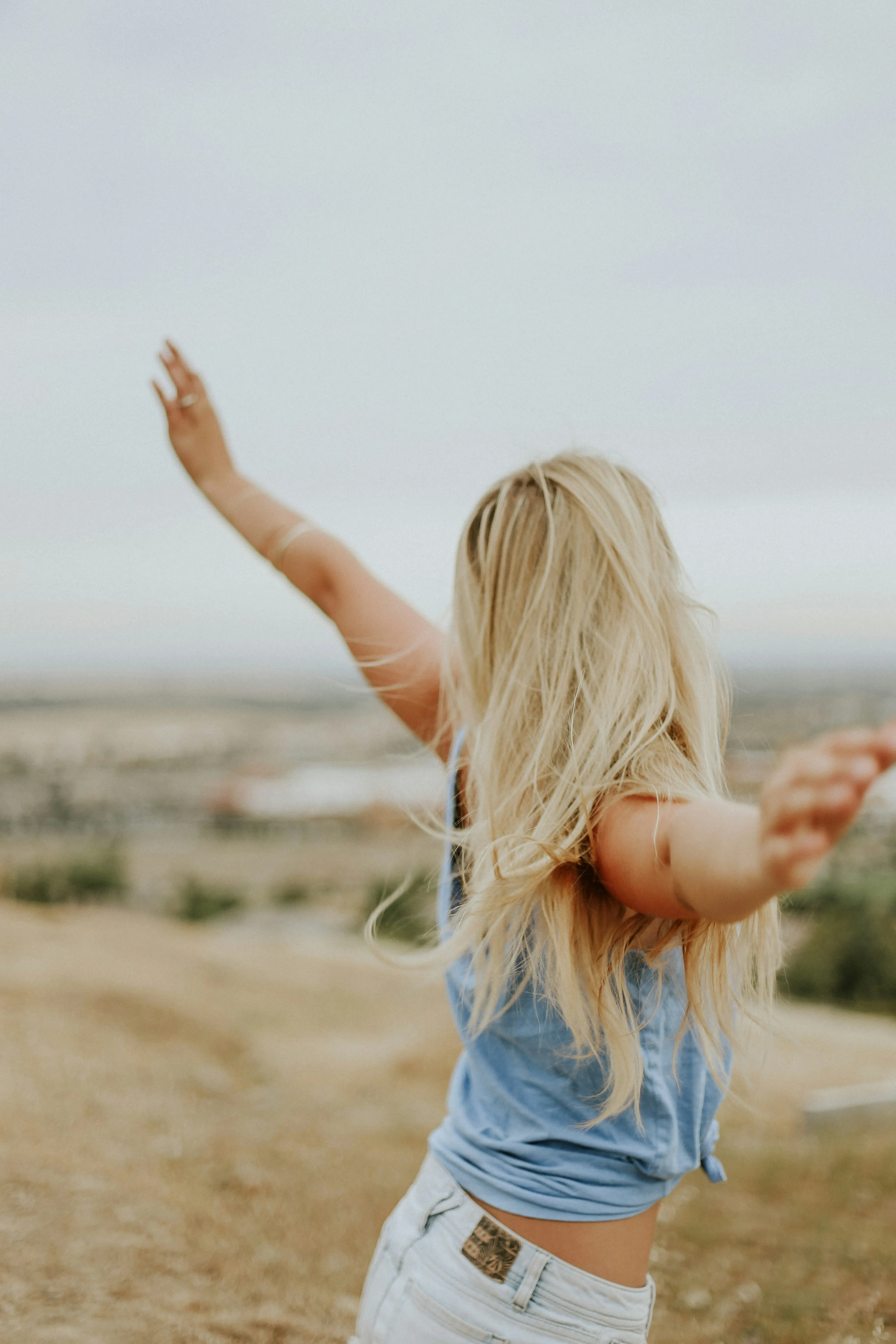 woman outside with arms outstretched in joy