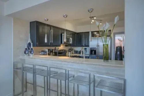 Elegant Eat-in Kitchen with Bar: Dine in style at this modern kitchen with a bar area. Experience the best of both worlds - the intimacy of a Private Villa and access to Resort Pool & Amenities just steps away.