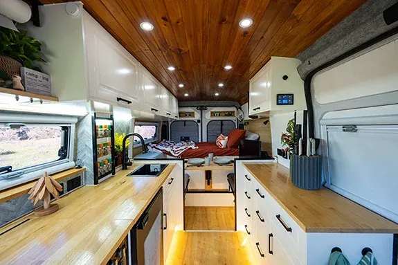 Self-built campervan interior showing kitchen layout, storage, and living space designed for full-time off-grid travel