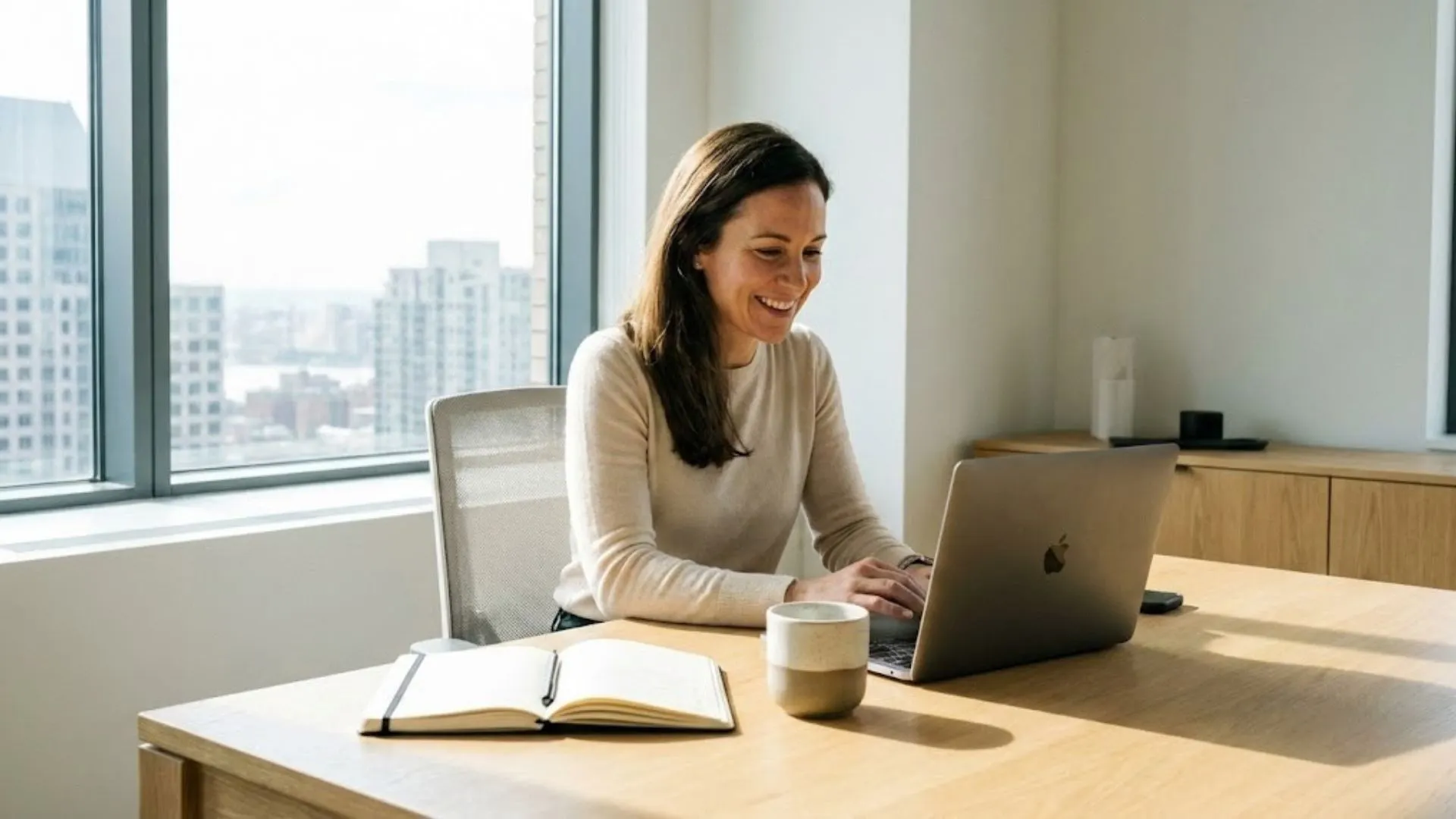  A confident small business owner working efficiently on a laptop at a clean, modern desk.