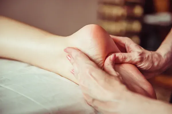 person massaging woman's foot