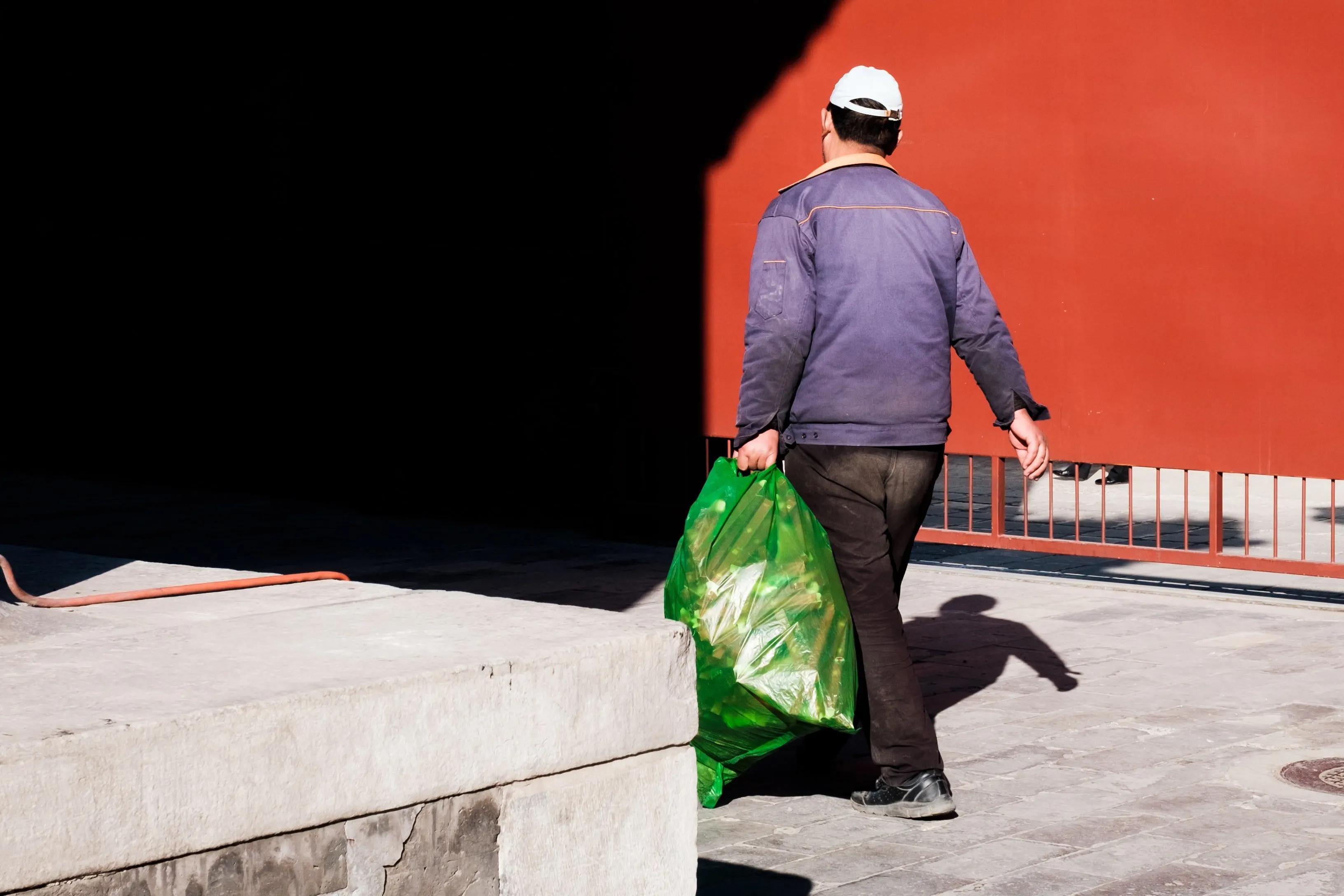 man removing trash bag from apartment doorstep