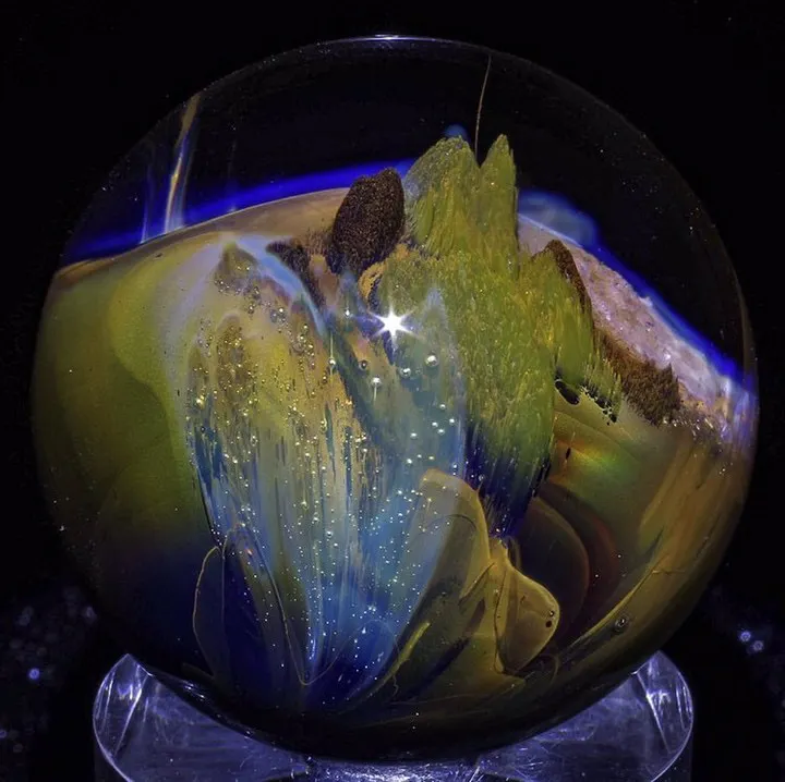 up close image of a glass marble being formed by a torch