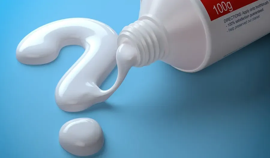 Tube of toothpaste with toothpaste coming out forming a question mark.