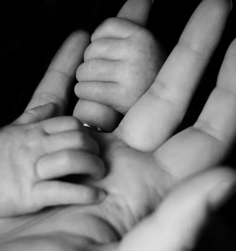 baby holding father's hand