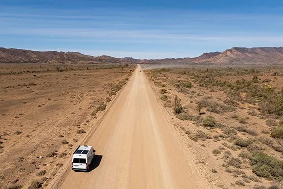 Fiat Ducato campervan driving along a remote Australian outback road