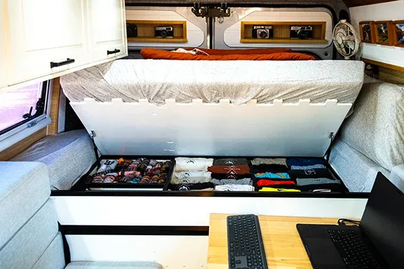 campervan lift-up bed with large under-bed storage in a DIY van conversion