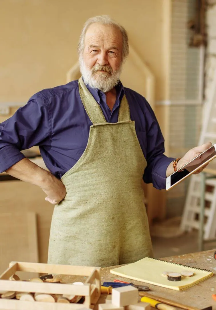 Roger holding and iPad and in his workshop
