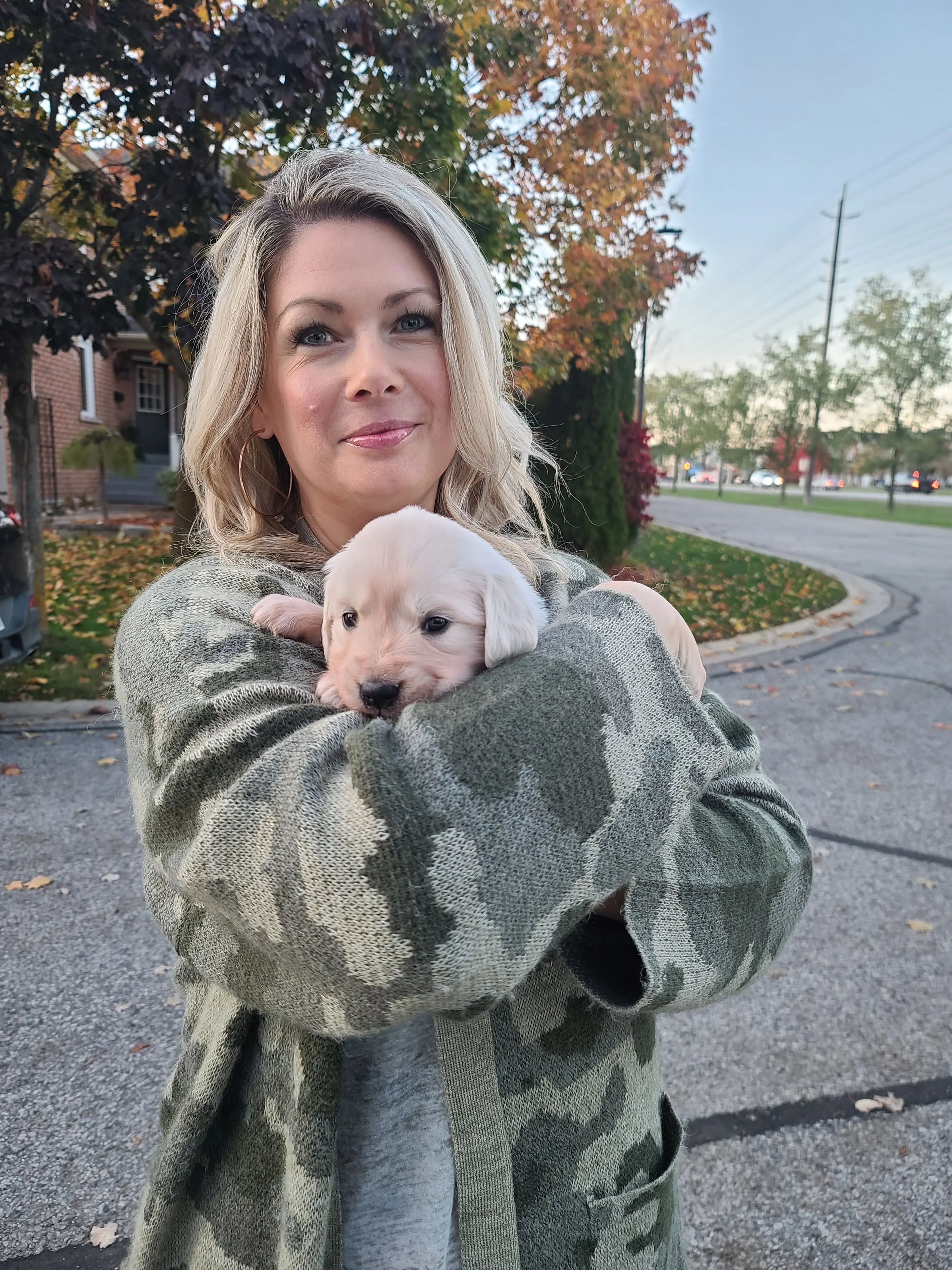 Owner of Brooklin Barkhouse holding a cream puppy