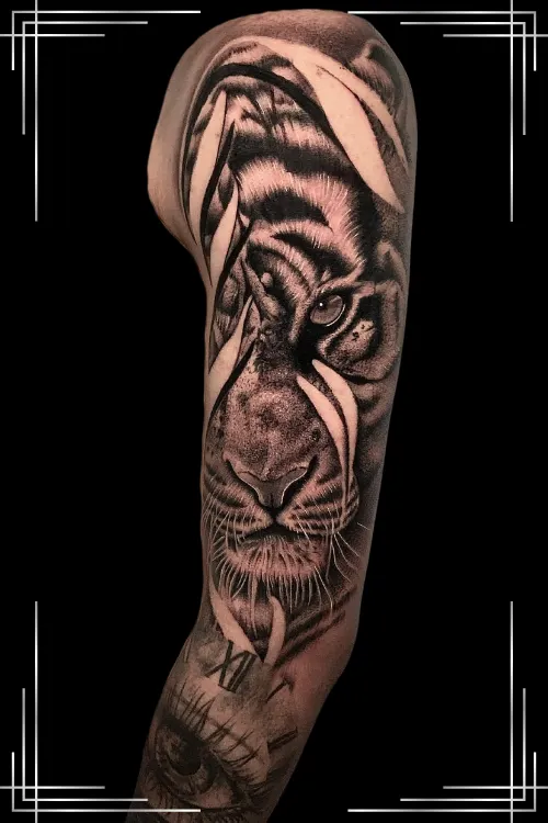 Imagen tatuaje de realismo deun felino sujetando en la boca la cara de una mujer